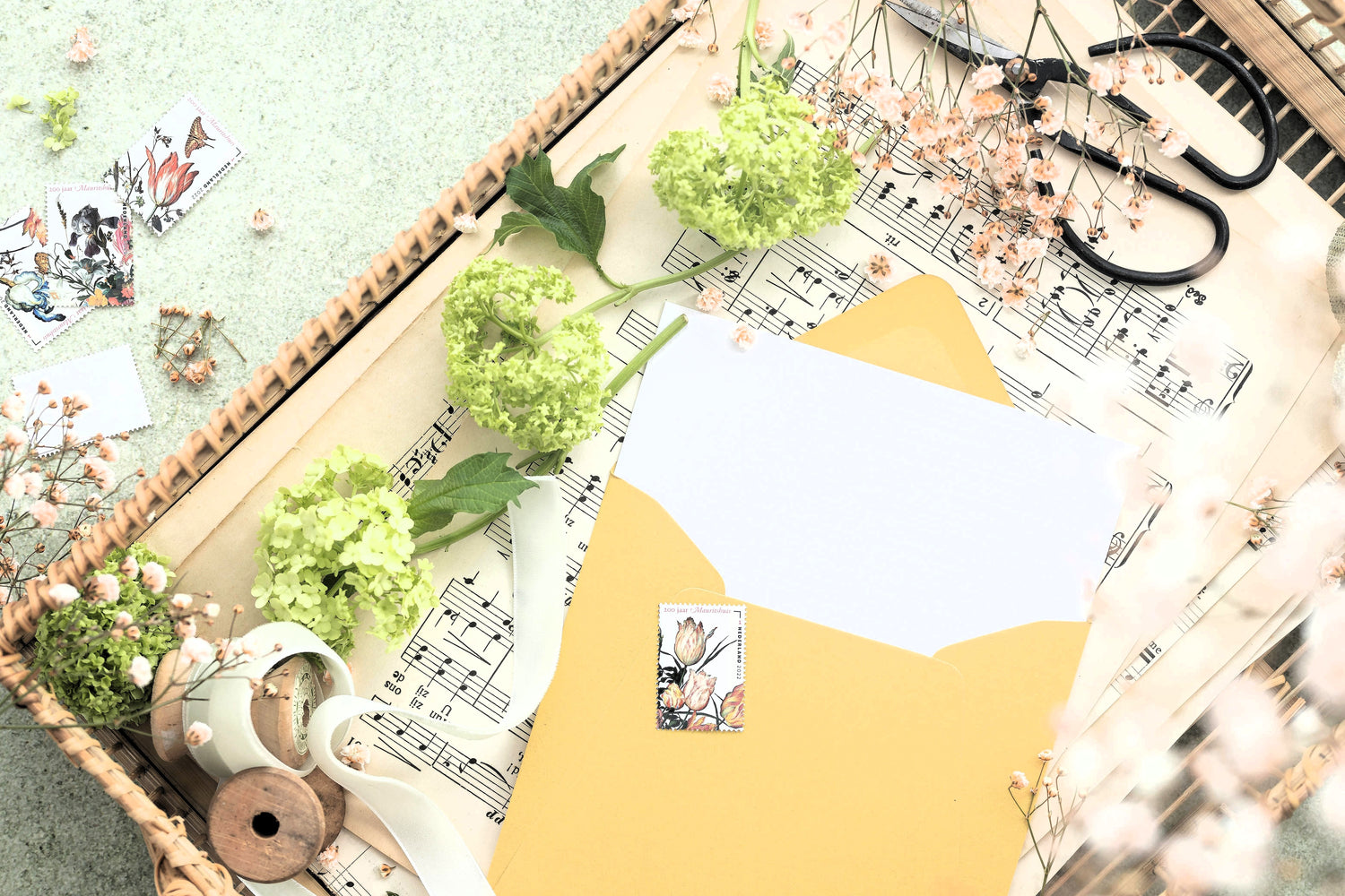 Compoziție artistică flatlay: flori, panglică și felicitare, materiale pentru proiecte handmade.