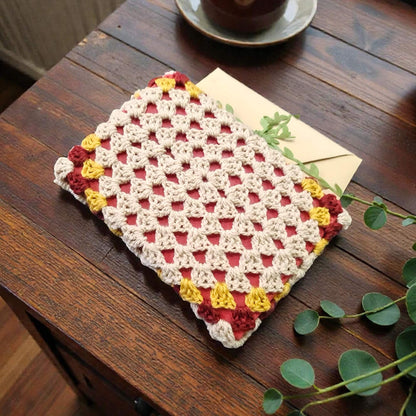 Husă de carte croșetată manual cu model triunghiuri, crem, roșu burgund și galben, unicat, perfectă pentru protejarea cărților și pasionații de lectură din România.