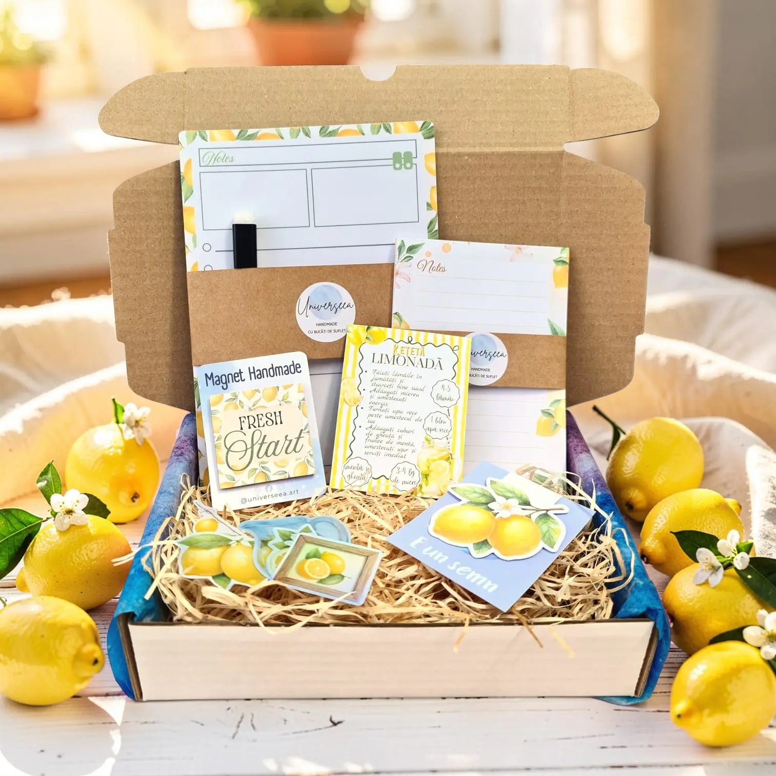 Componentele setului cadou Fresh Start așezate împreună: planner magnetic A5, notepad, semn de carte și accesorii cu lămâi