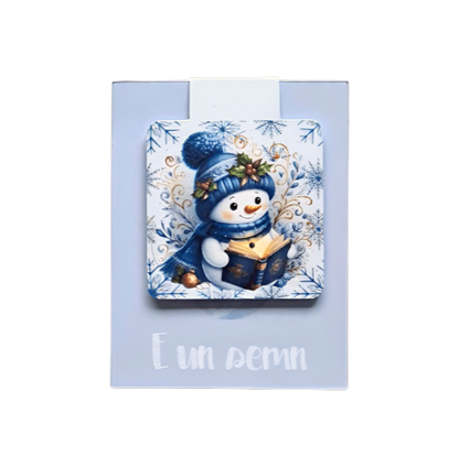 semn de carte magnetic cu ilustratie om de zapada care citeste in atmosfera de craciun