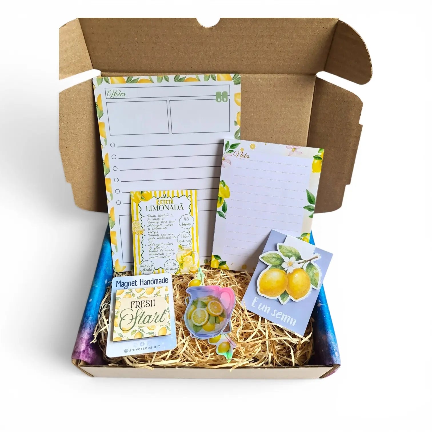 Set cadou handmade cu planner A5, semn de carte magnetic, magneți și accesorii de papetărie așezate pe fundal alb